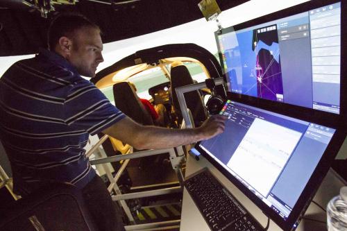 Erick Stoecker (BS, Computer Science, 2002) demonstrates how instructors can change variables in training pilots with the AS 350 simulator.