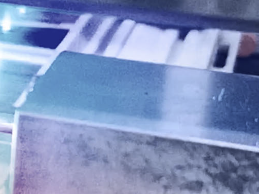 A pink, purple, and blue image of a piece of metal.