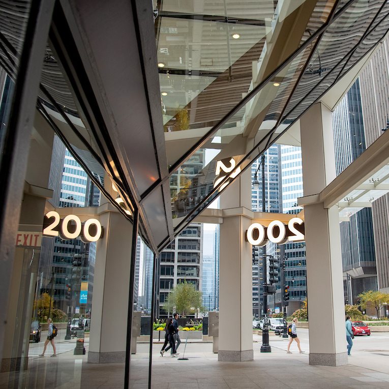 A front entrance with the number 200 of a white high-rise.