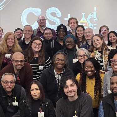 A large group of people smile for the camera.