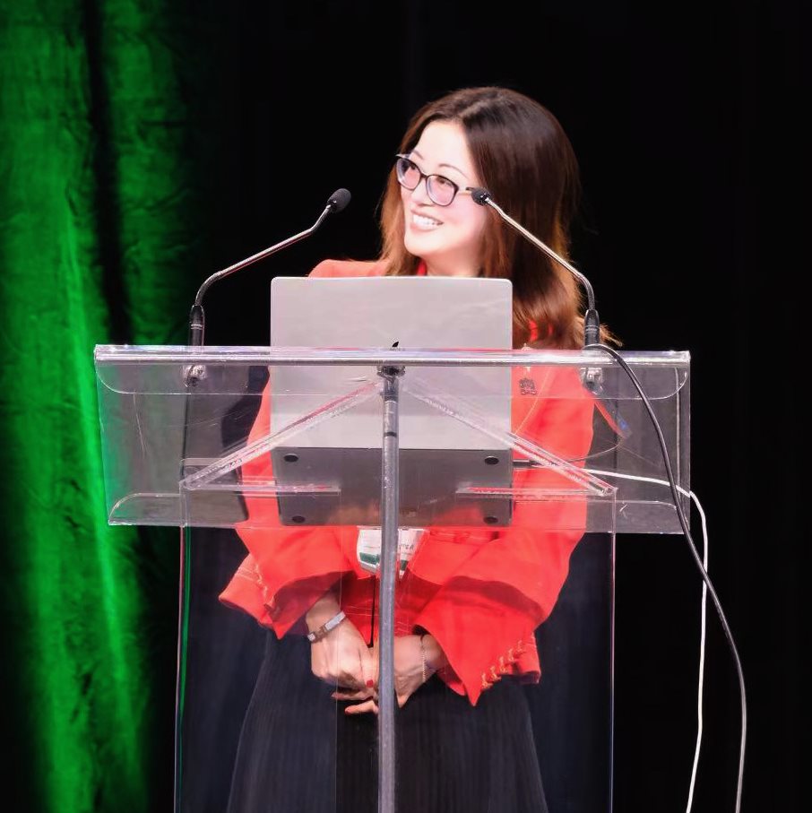 CS professor Heng Ji at the podium of the  IJCAI conference.