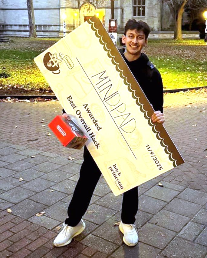 A person holds a giant check and smiles