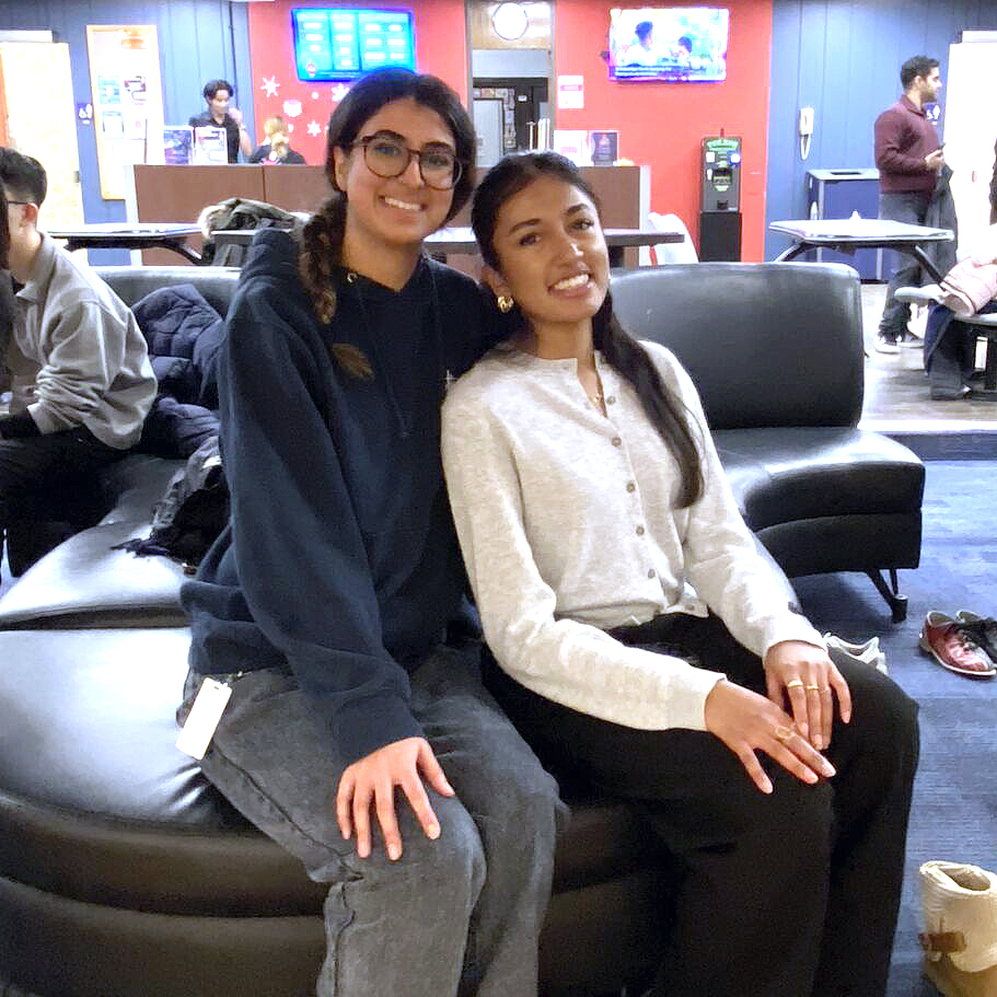 Two people sit and smile.