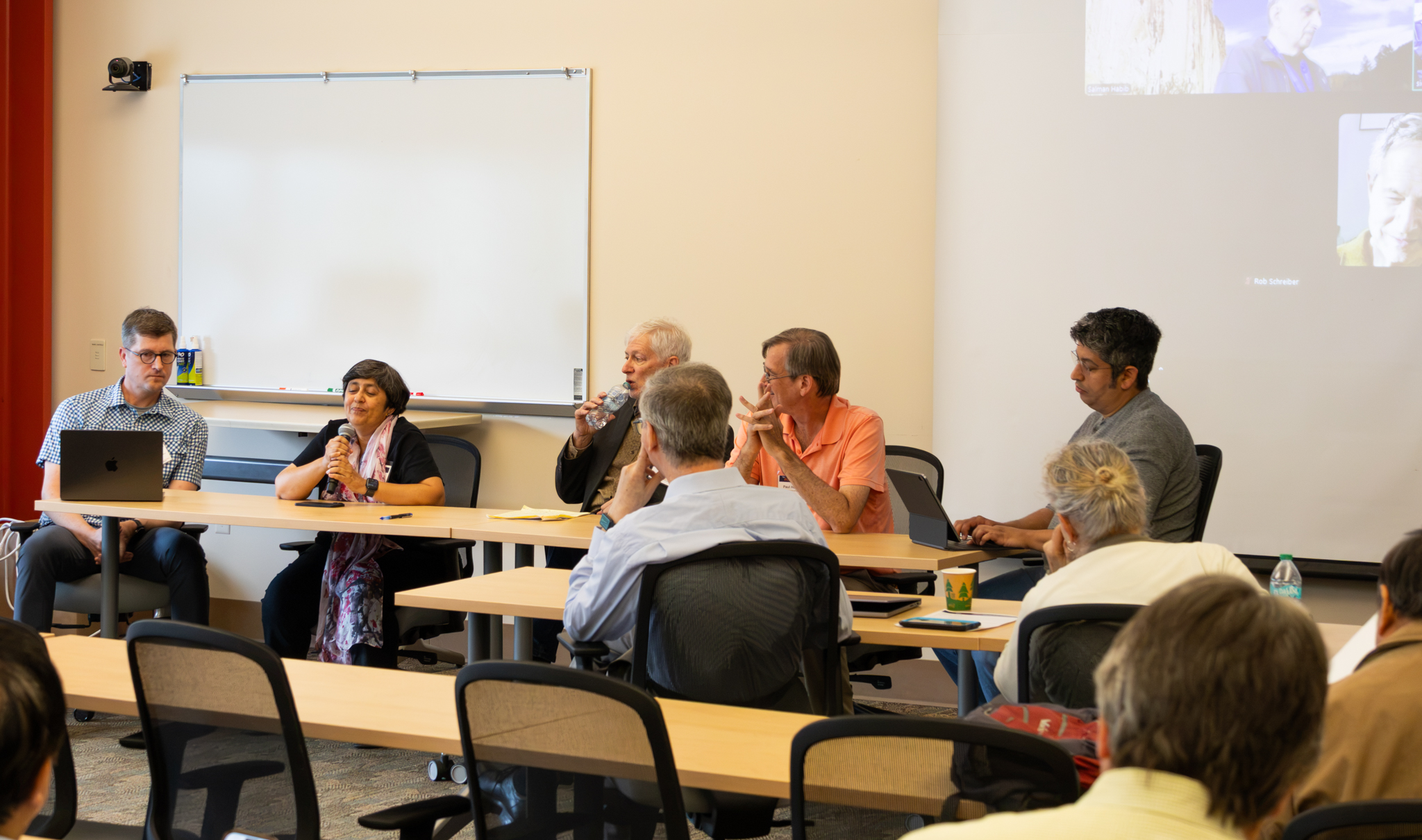 People sit at tables in a conference room.