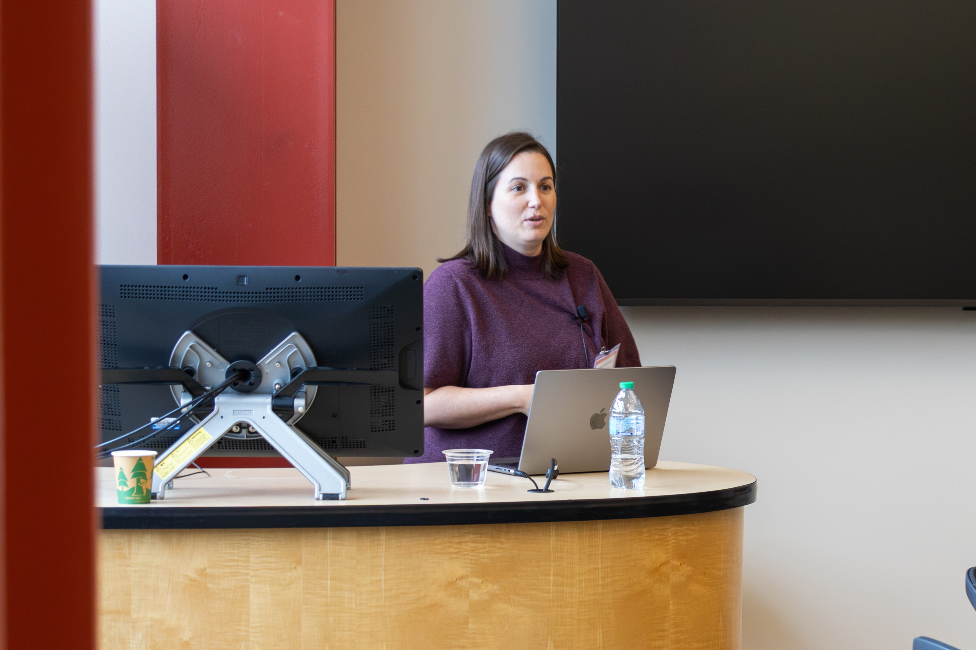 A woman stands behind a podium