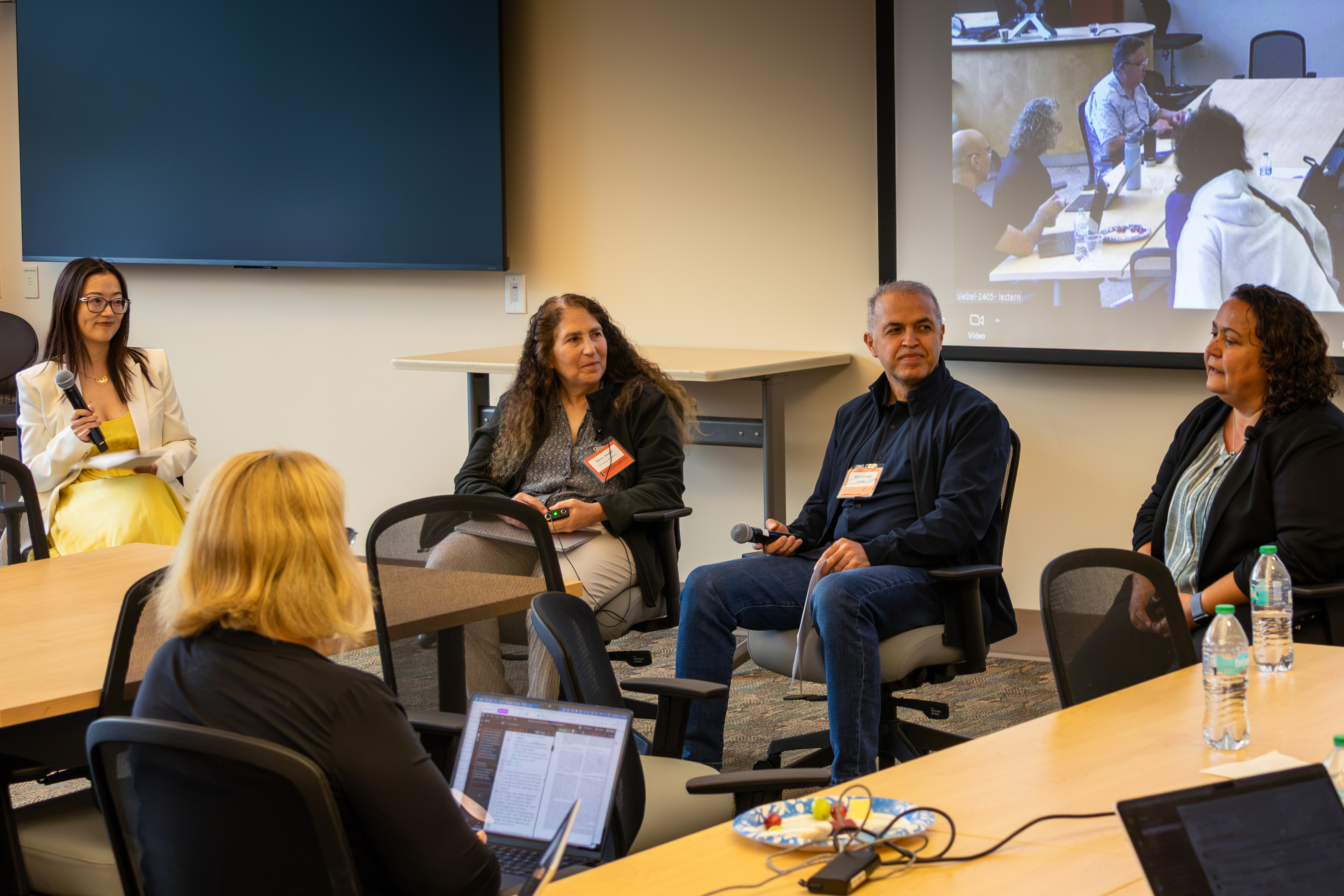 Four people sit in chairs facing another person sitting in a chair