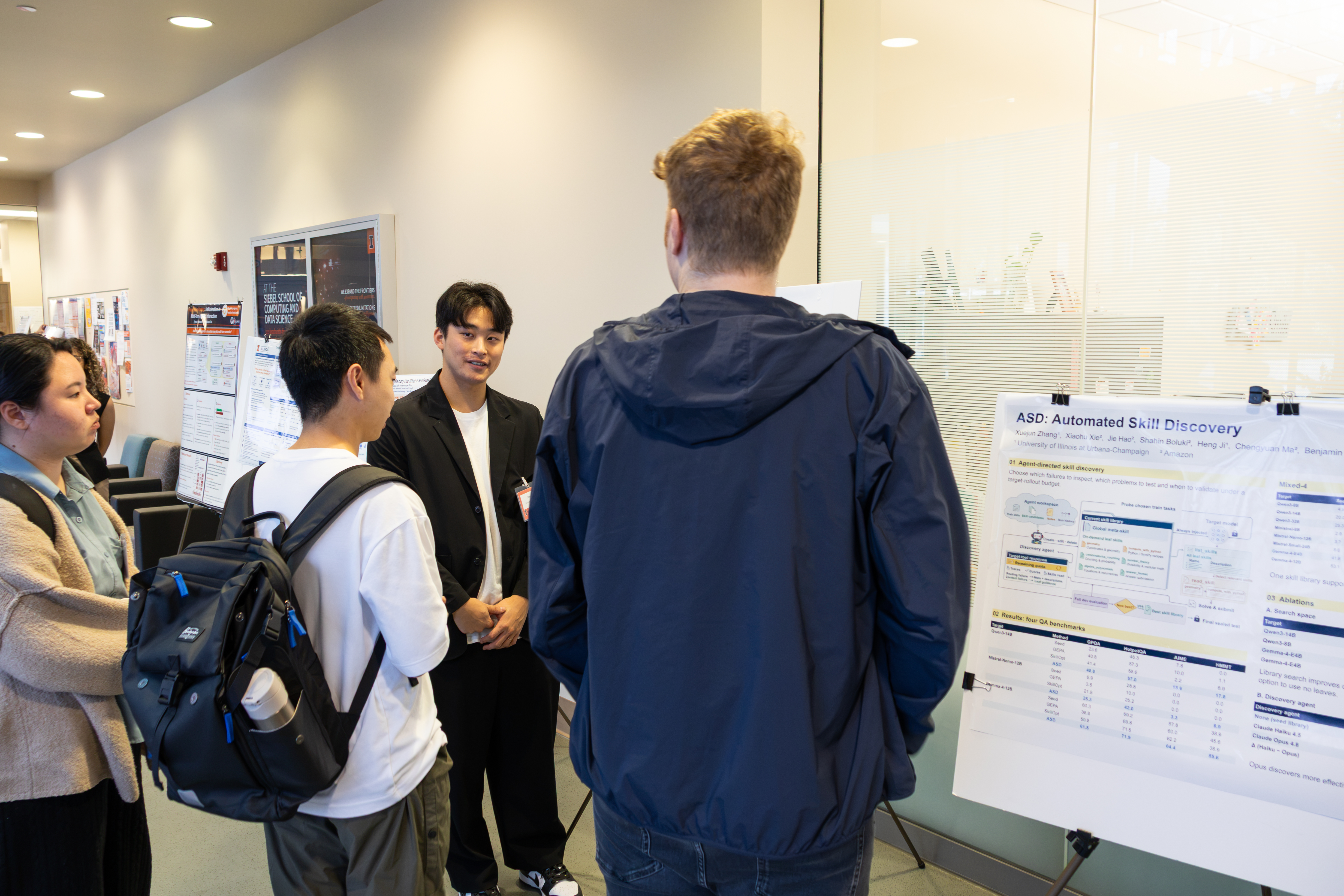 Four people stand in front of a research poster