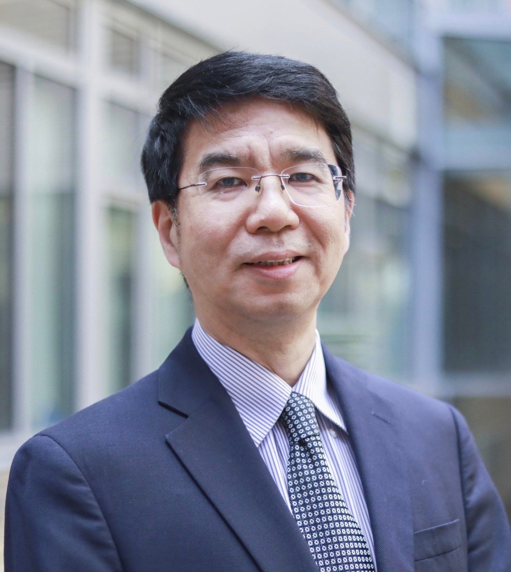 Illinois CS alumnus Jason Cong portrait photo, posed in front of a building with a blue suit on.