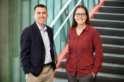 Illinois Computer Science profcessor Colleen Lewis (right) and Paul Bruno, professor of Education Policy, Organization and Leadership, won a $500,000 award pose standing near the bottom of a staircase. Lewis and Bruno were Co-PIs on a proposal analyzing CS and educational policy from the National Science Foundation.