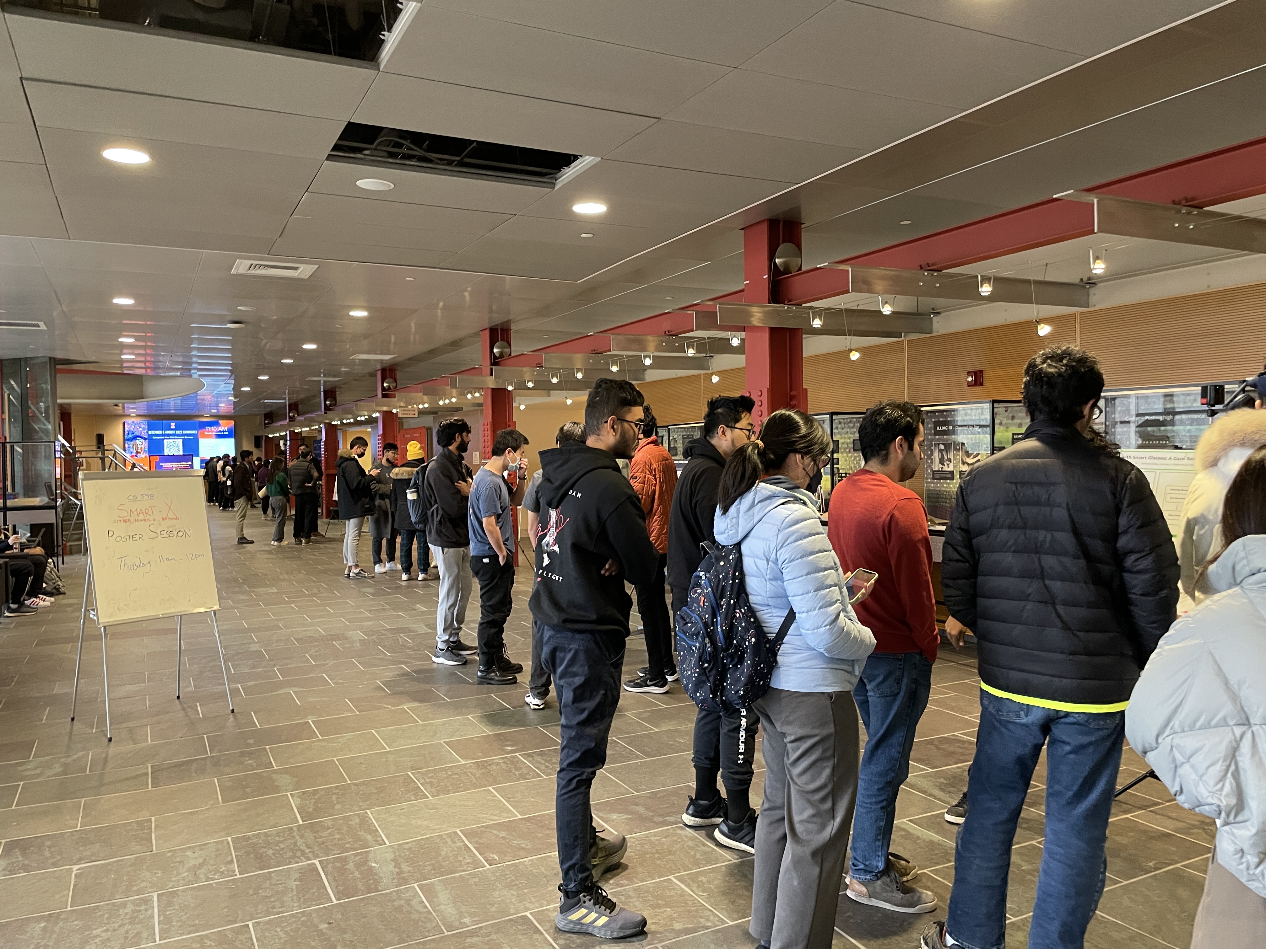 Illinois CS students lined up in the Thomas M. Siebel Center for Computer Science Atrium viewing their other student projects and posters.