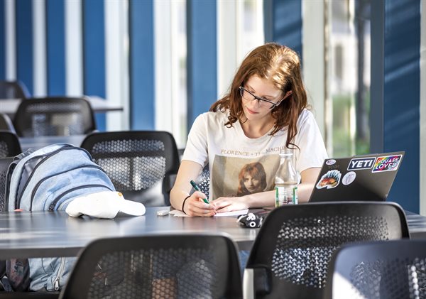 Student smiling at laptop