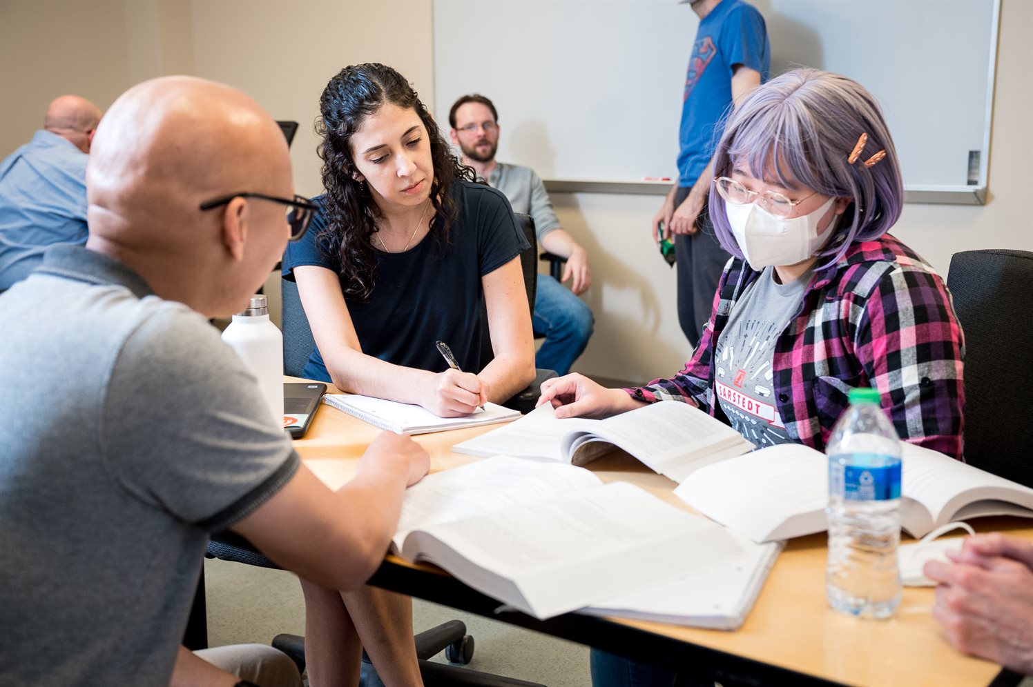 Three students sit around a table and study computer science inside a classroom at the Siebel Center for Computer Science.