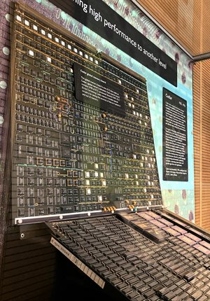 A brown board in a display case with buttons and wires.