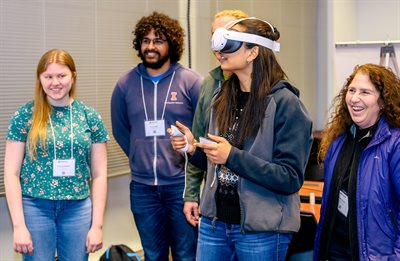 While others watch, a person tries an immersive virtual reality (VR) headset.