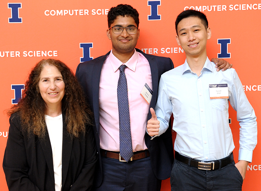 People pose in front of an orange banner at the 2024 Computer Science Celebration of Excellence