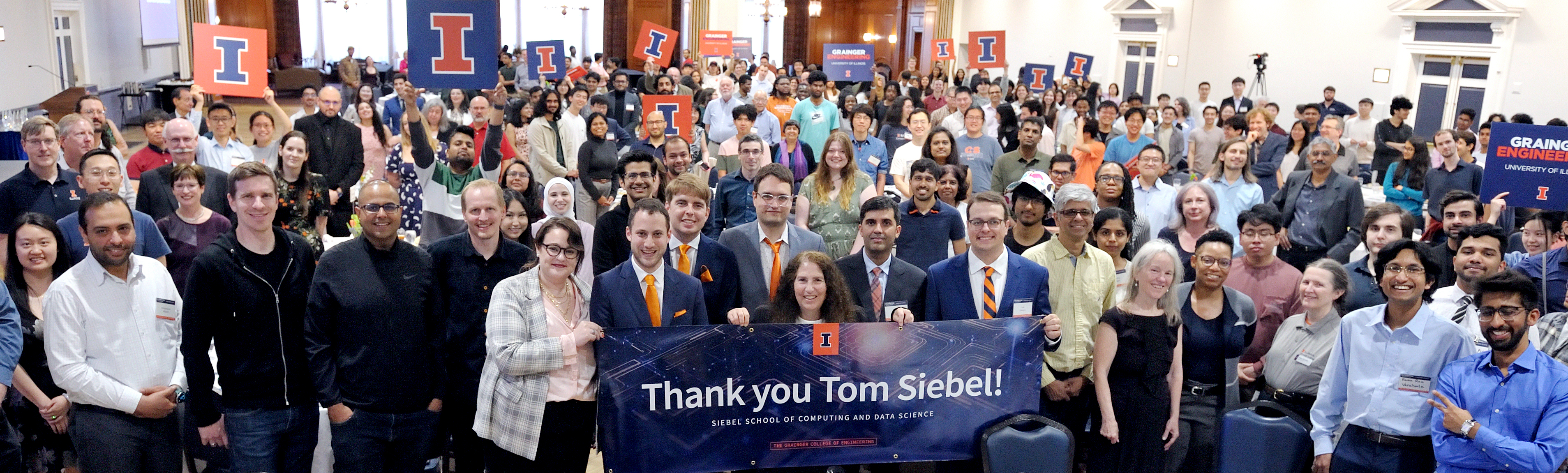 People hold signs that say Thank you Tom Siebel! sign at the 2024 Computer Science Celebration of Excellence