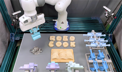 A robot arm arranges lettering and dumpling dough.