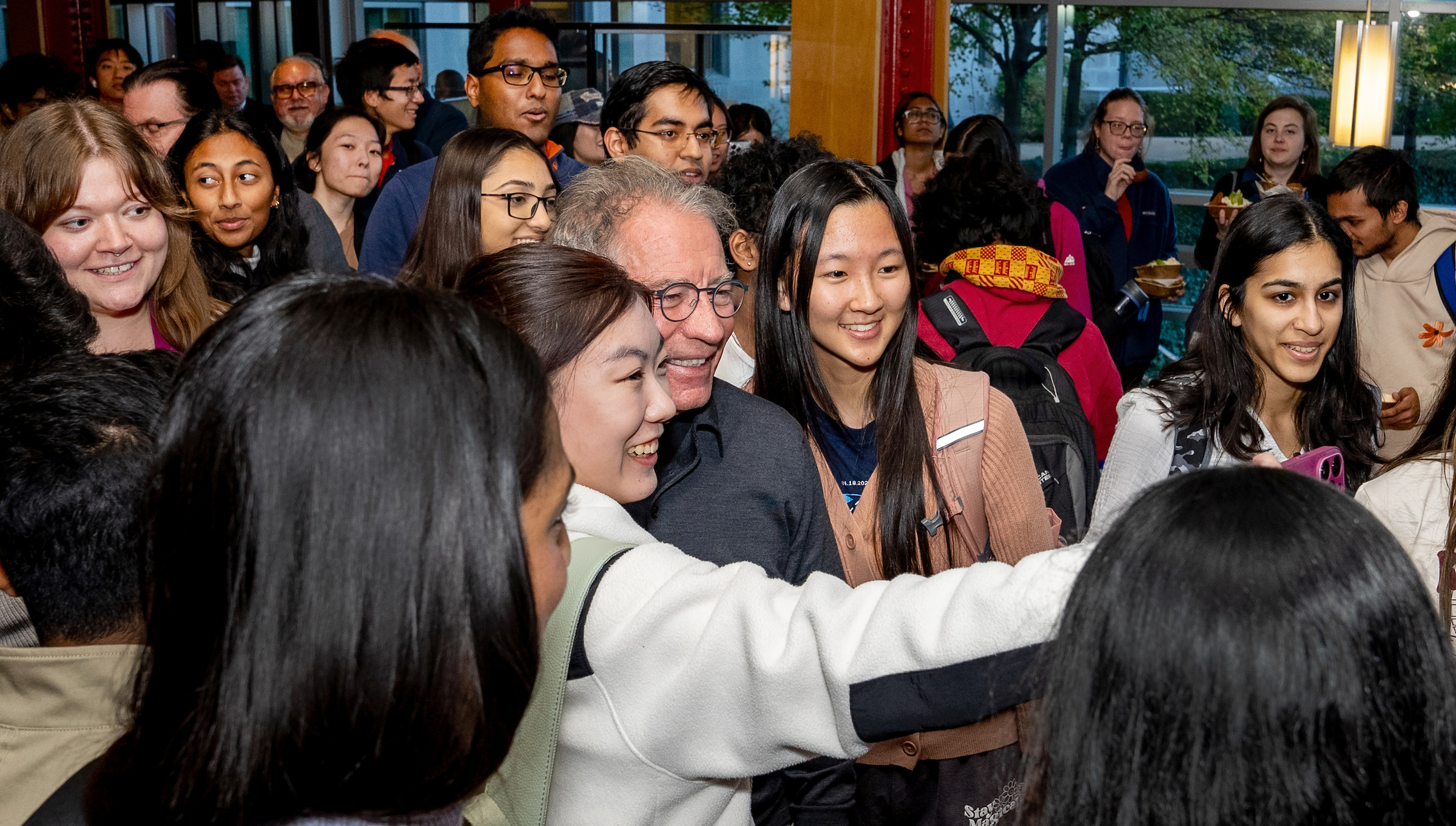 A large group of people take a selfie. 