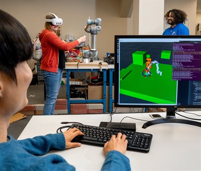 CS STARS members demonstrate computer visualization with a headset and computer at the 2024 Trick of Research event.