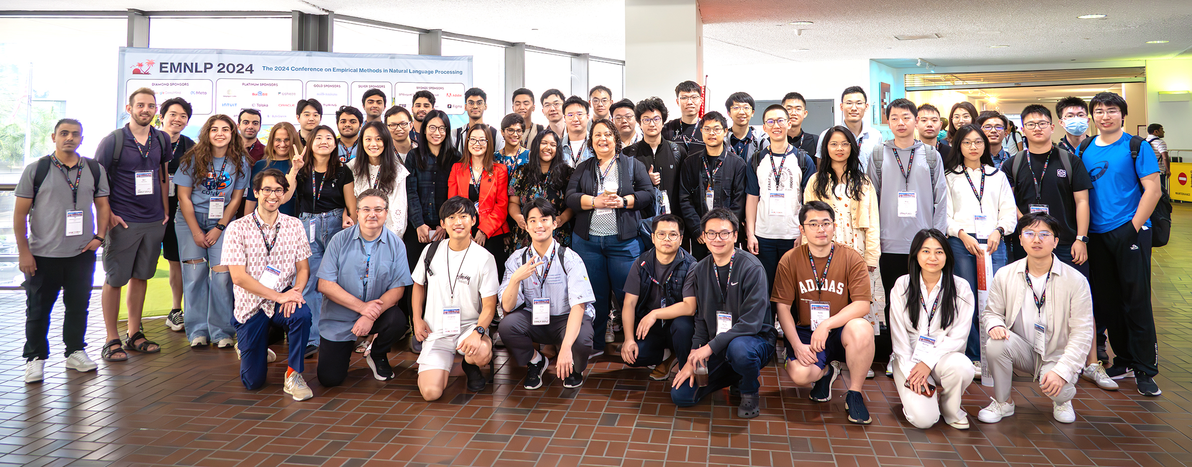 A very large group of people at a conference pose and smile for the camera.